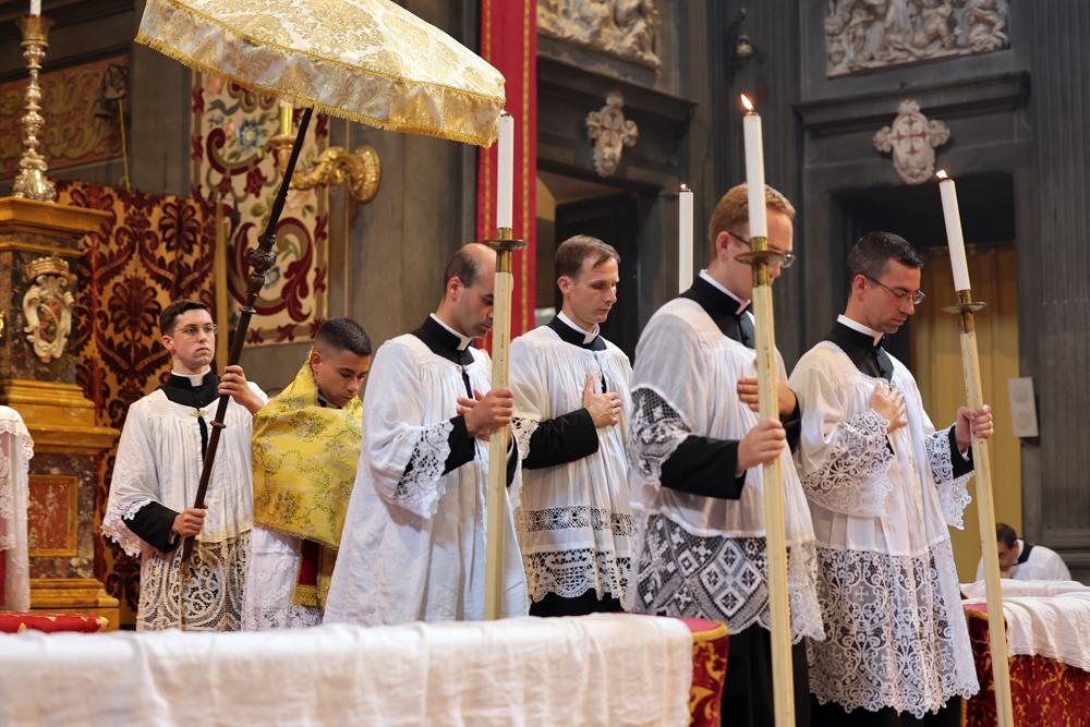 Le Saint-Sacrement, précédé des flambeaux, est porté en procession à l&rsquo;autel latéral