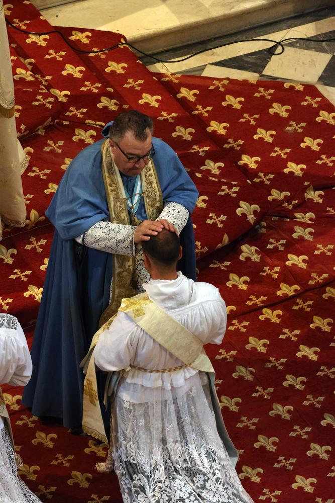 Les prêtres présents imposent les mains aux ordinands