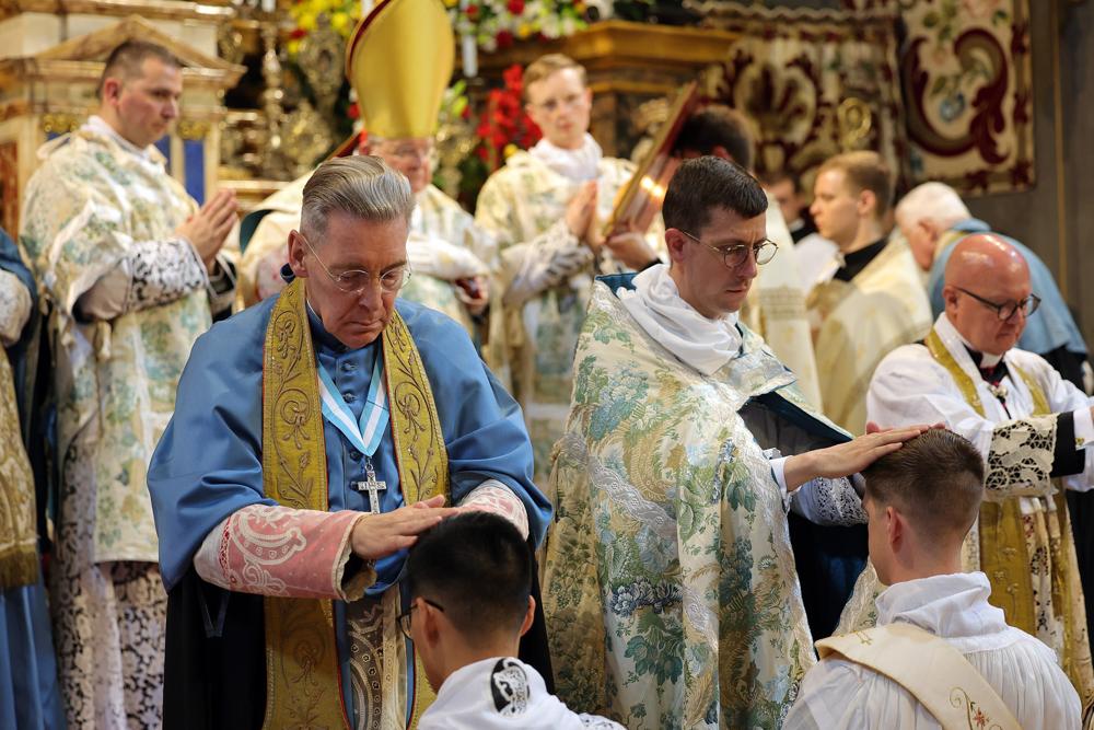 Les prêtres présents imposent les mains aux ordinands