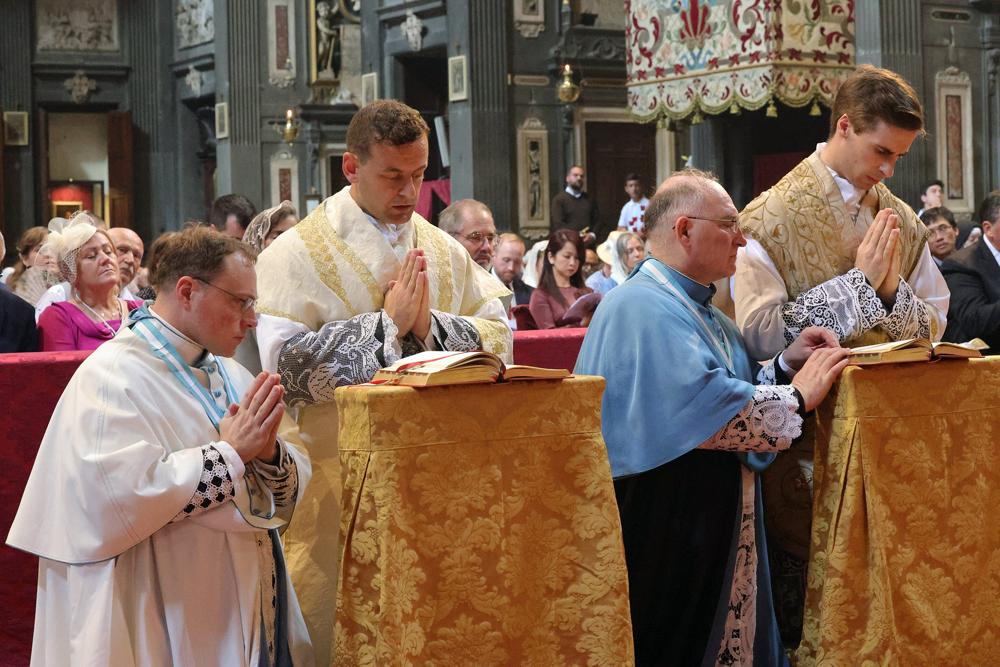 Les jeunes prêtres, assistés par un chanoine, récitent les prières de la Messe avec le Pontife 