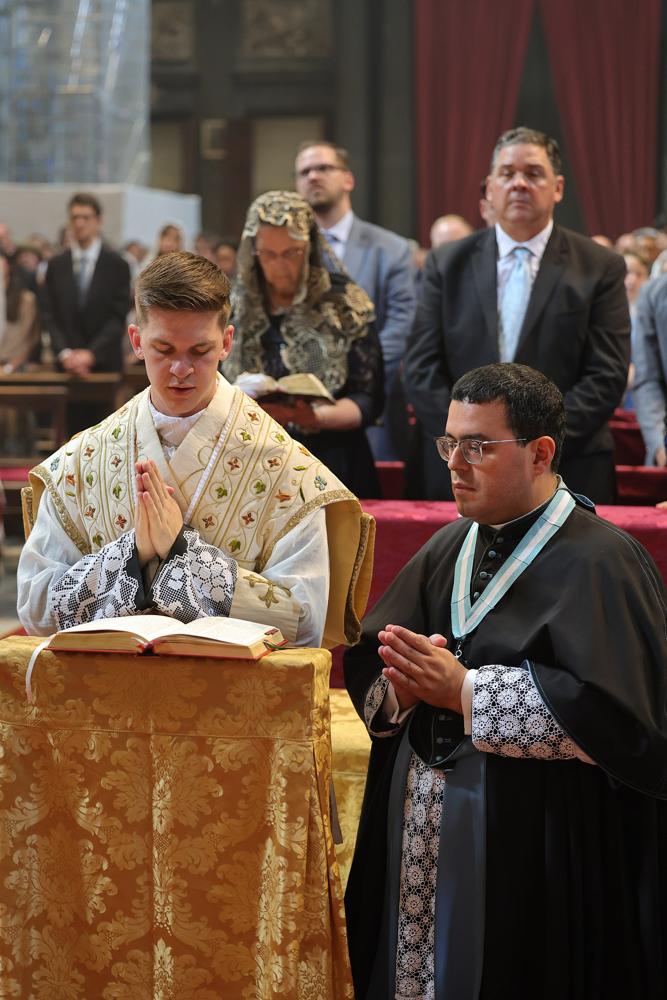 Les jeunes prêtres, assistés par un chanoine, récitent les prières de la Messe avec le Pontife