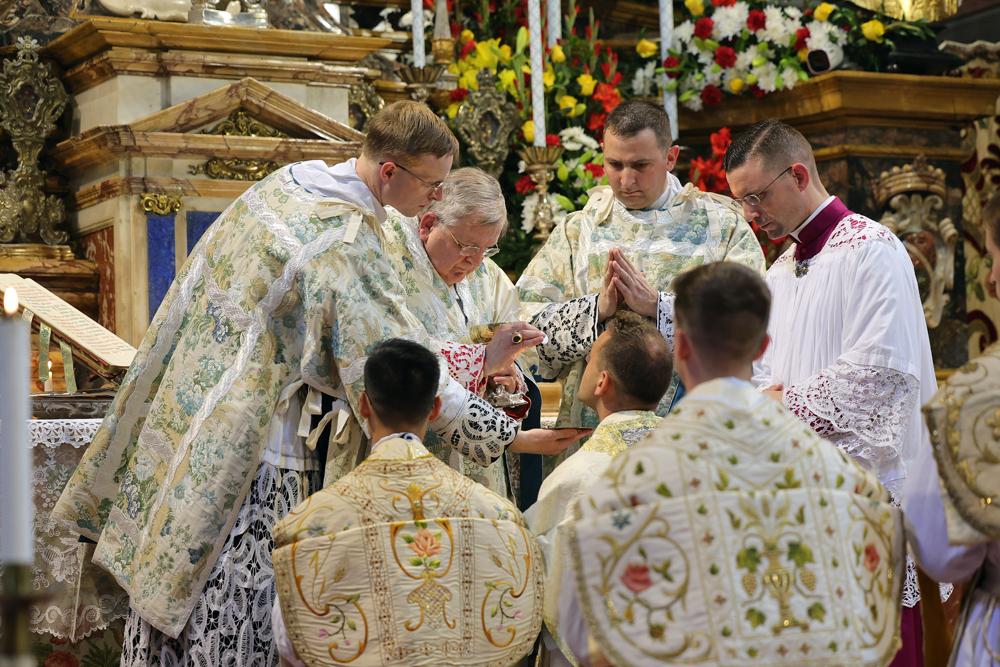 Les nouveaux prêtres reçoivent la communion de la main du Pontife après avoir baisé son anneau