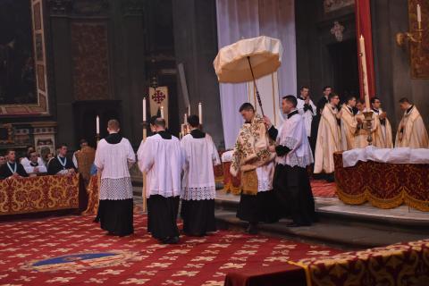 Après la Communion, un prêtre porte le ciboire à l&rsquo;autel du Saint-Sacrement précédé des céroféraires